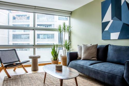 a living room with a blue couch and a table at New 2BR with pool and rooftop in Mexico City