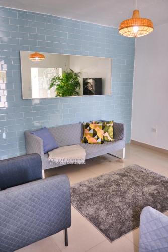 a living room with a couch and a blue wall at The Pelican Poshtel in San Juan