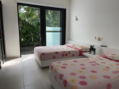 a bedroom with two beds and a cat statue in it at Casa HESTIA Condominio Campestre el Peñon Girardot in Girardot
