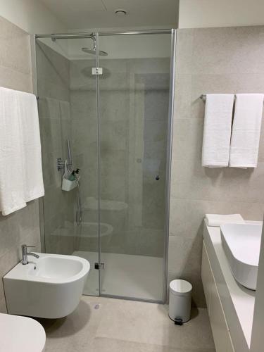 a bathroom with a shower and a toilet and a sink at Leça Apartments in Leça da Palmeira