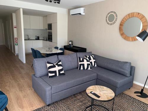 a living room with a blue couch and a table at Leça Apartments in Leça da Palmeira