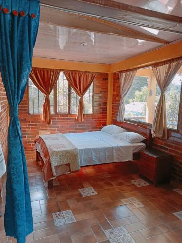 a bedroom with a bed in a brick wall at MI RANCHITO in Sogamoso