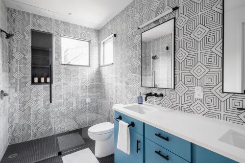 a bathroom with a toilet and a sink and a mirror at East Austin Modern Bungalow in Austin