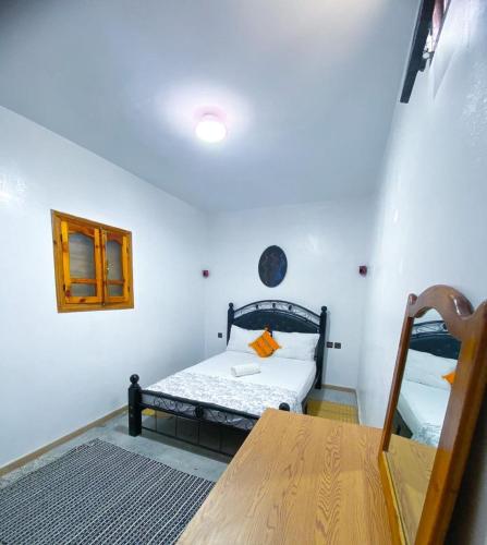 Cette petite chambre comprend un lit et une table. dans l'établissement Idriss's hostel, à Taghazout