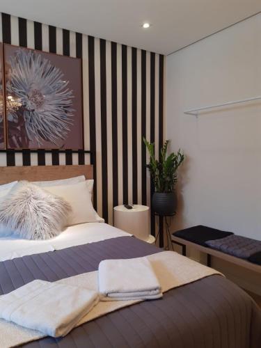 a bedroom with a bed with a striped wall at Live House Boutique Hotels in Sao Paulo