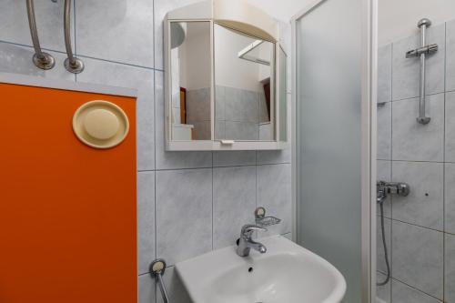 La salle de bains est pourvue d'un lavabo et d'un miroir. dans l'établissement Apartment Mimice 11045b, à Mimice
