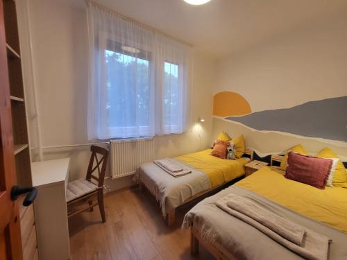 um quarto com 2 camas e uma janela em Koala Apartman Székesfehérvar em Székesfehérvár