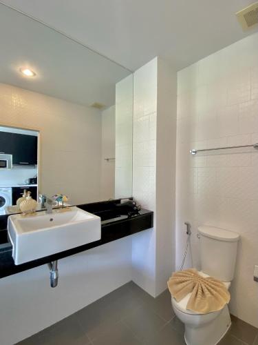 a white bathroom with a sink and a toilet at Studio near Karon Beach by Clavis in Karon Beach