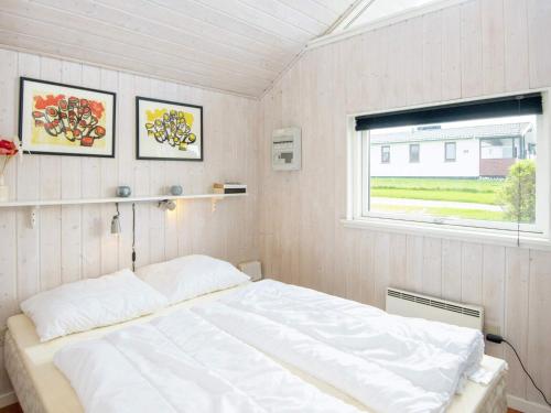 1 dormitorio con cama blanca y ventana en Two-Bedroom Holiday home in Lemvig 1, en Lemvig