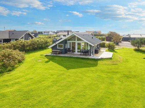 a small house in a yard with a green lawn at 4 person holiday home in Lemvig-By Traum in Lemvig