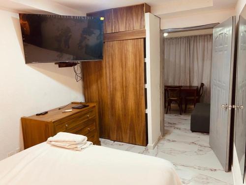 - une chambre avec un lit, une télévision et une table dans l'établissement 3 Departamentos con 5 Habitaciones en Zona Romántica, à Puerto Vallarta