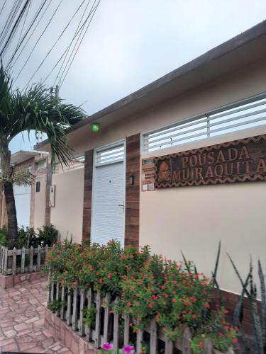 a building with a sign on the side of it at Pousada Muiraquitã Parintins in Parintins