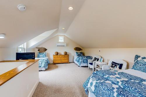 1 dormitorio en el ático con 1 cama y 2 sillas en About Time en Nantucket