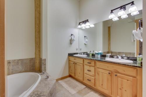 a bathroom with two sinks and a tub and a mirror at Lovely Big Sky Getaway Near Skiing and Golf! in Big Sky