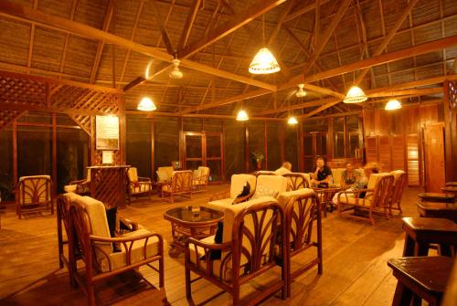 Habitación grande con mesas y sillas. en Sandoval Lake Lodge, en Puerto Maldonado