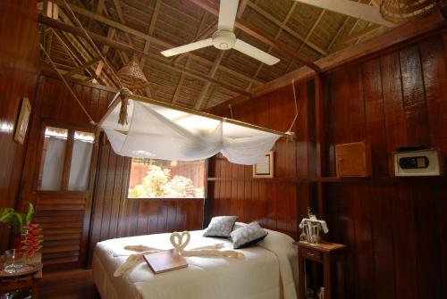 a bedroom with a bed with a window and a ceiling at Sandoval Lake Lodge in Puerto Maldonado