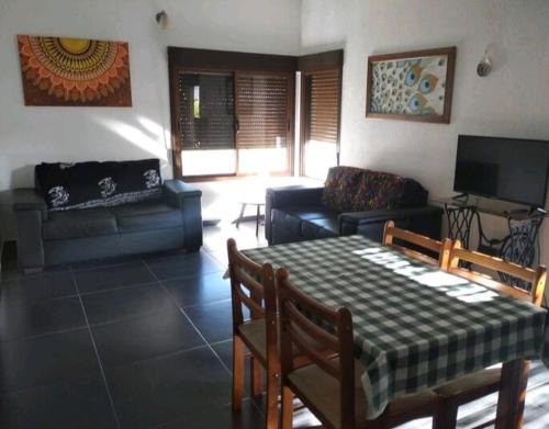 ein Wohnzimmer mit einem Tisch und einem Sofa in der Unterkunft Casa 3 dormitorios en Colonia Valdense in Colonia Valdense