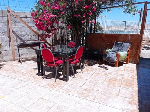 een tafel en stoelen op een patio met roze bloemen bij Suite Loreto in Caldera