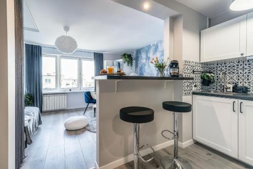 uma cozinha com dois bancos num pequeno quarto em DREAMY modern 3ppl apartment 13 min to Old Town and Central Station em Varsóvia