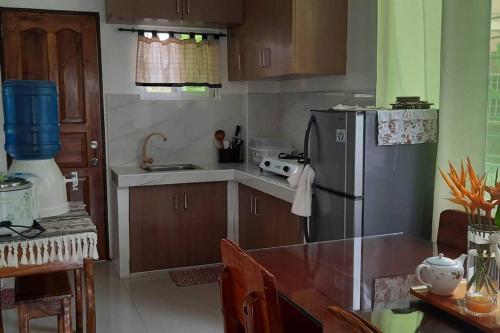 eine Küche mit einem Kühlschrank aus Edelstahl und einem Tisch in der Unterkunft Bayay ni Mayang (Fully furnished apartment) in Surigao