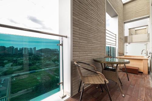 a balcony with a table and chairs and a view of the city at OCEAN PARK 9 in Incheon