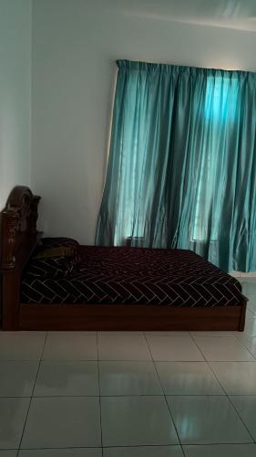 uma cama num quarto com uma cortina azul em Amir homestay kg pandan em Kuantan