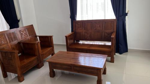 three wooden chairs and a table in a room at Amir homestay kg pandan in Kuantan