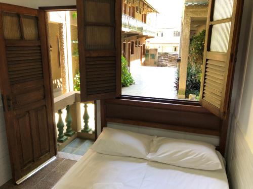 een bed in een kamer met een open raam bij Pousada O Meu Canto in Santa Rita de Jacutinga