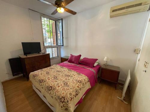 a bedroom with a bed and a flat screen tv at Comodo Y Acogedor Departamento En La Boca in Buenos Aires