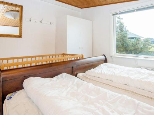 two beds in a room with a window at Three-Bedroom Holiday home in Harboøre 12 in Harboør