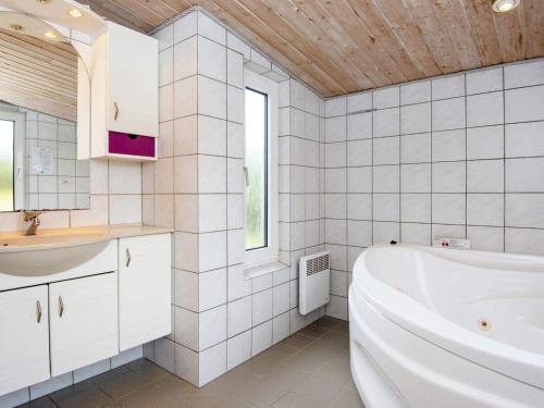 a white bathroom with a tub and a sink at Three-Bedroom Holiday home in Harboøre 12 in Harboør