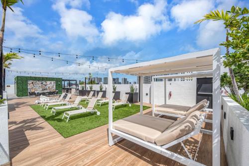 a patio with lounge chairs and tables on a roof at Stylish Unit in Downtown Miami With Free Parking in Miami