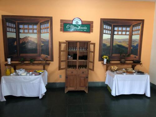 twee tafels in een kamer met witte tafelkleden bij Pousada O Meu Canto in Santa Rita de Jacutinga