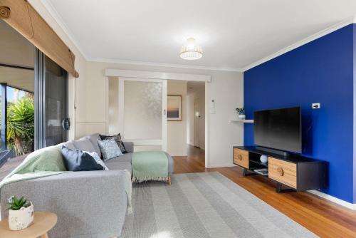 a living room with a couch and a tv at Back Beach Oasis in Smiths Beach
