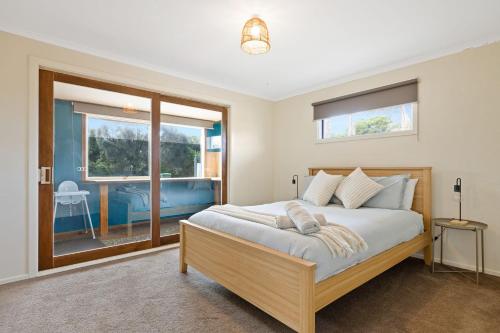 1 dormitorio con cama y ventana grande en Back Beach Oasis, en Smiths Beach