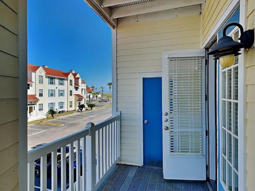 a porch with a blue door on a house at Toes In The Water II in Padre Island