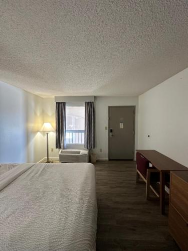 a hotel room with a bed and a desk and a window at Days Inn by Wyndham Decatur Priceville I-65 Exit 334 in Decatur