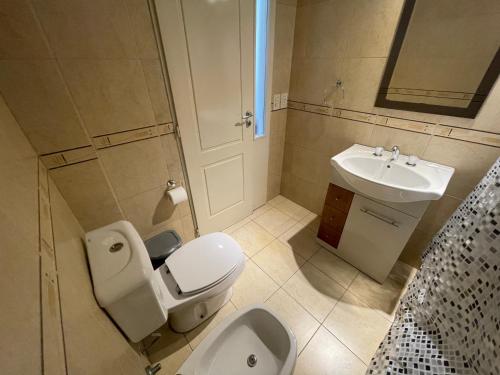 La salle de bains est pourvue de toilettes et d'un lavabo. dans l'établissement Splendid Temporary Stay in Almagro 10th Floor with Pool, à Buenos Aires