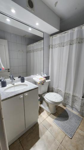 a bathroom with a toilet and a sink and a mirror at Hermoso Departamento Iquique in Iquique