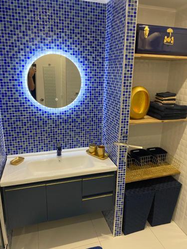 Baño con lavabo con una luz azul encima en Au PETIT NONI en Le Gosier