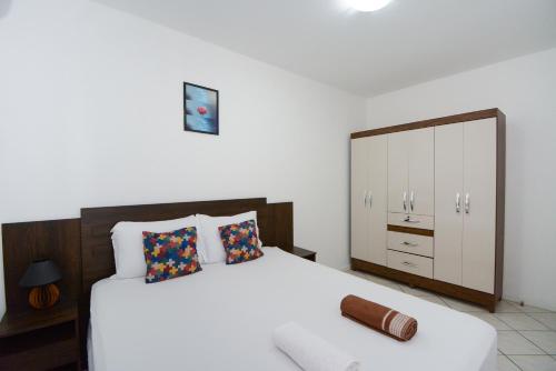 ein Schlafzimmer mit einem großen weißen Bett und einer Kommode in der Unterkunft ótima localizacao e perto de tudo in São José