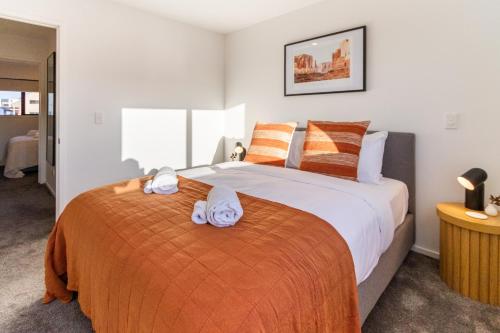 ein Schlafzimmer mit einem großen Bett mit Handtüchern darauf in der Unterkunft Garden City Getaway 2 bed with sofa bed 1 bath in Christchurch