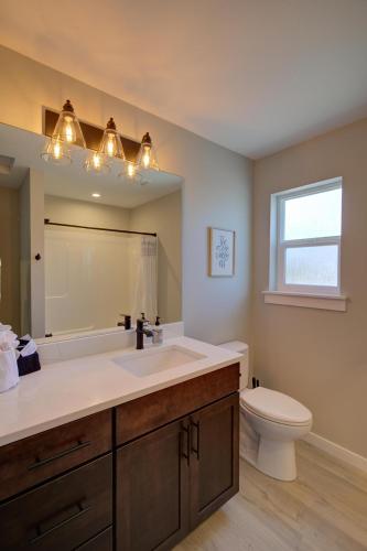 a bathroom with a sink and a toilet and a mirror at Sand By Me in Ocean Shores