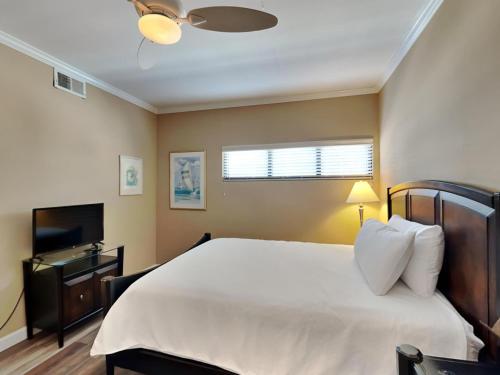 ein Schlafzimmer mit einem großen Bett und einem TV in der Unterkunft Palm Beach Club 125 in Pensacola Beach