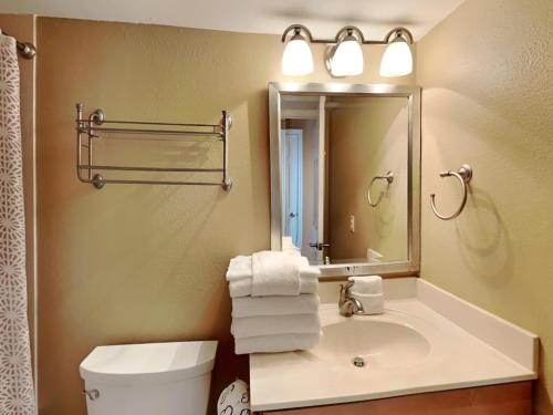 W łazience znajduje się umywalka, toaleta i lustro. w obiekcie Palm Beach Club 125 w mieście Pensacola Beach