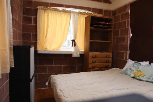 een slaapkamer met een bed en een raam bij KOLSA in Santa María Tonantzintla