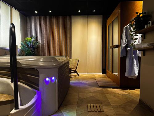 HOTEL & SPA Le Renard Centre في شالون أون شامباني: حمام مع حوض ومغسلة مع أضواء أرجوانية