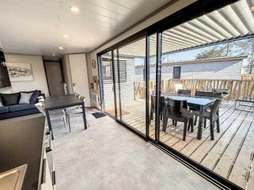une cuisine et une salle à manger avec une grande porte coulissante en verre. dans l'établissement Chalet Jullouville - 6 pers. - Piscine chauffée - Terrasse privative - Proche plage et commerces - FR-1-361-470, à Jullouville