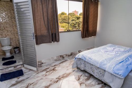 a bedroom with a bed and a window at Uai Só Hostel in Belo Horizonte