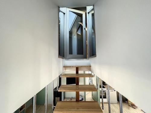 a stair case in a building with a mirror at Maison rénovée 3 chambres, proche mer, jardinet équipé, centre-ville - FR-1-361-464 in Jullouville-les-Pins
